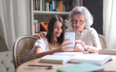 Oma en kleinkind die samen naar de mobiel kijken