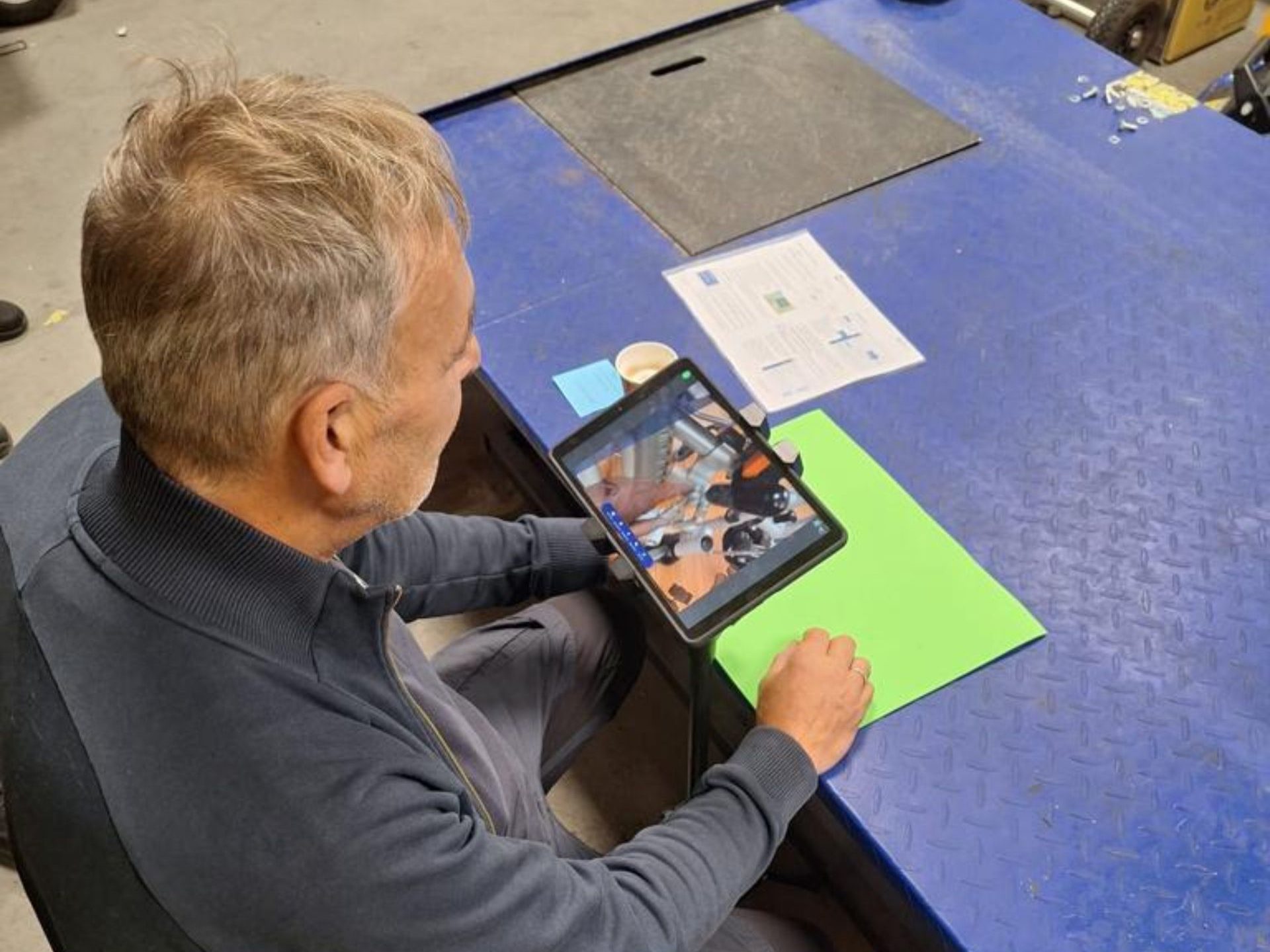 Een persoon kijkt naar een tablet waar te zien is dat hij naar een onderdeel van een hulpmiddel wijst